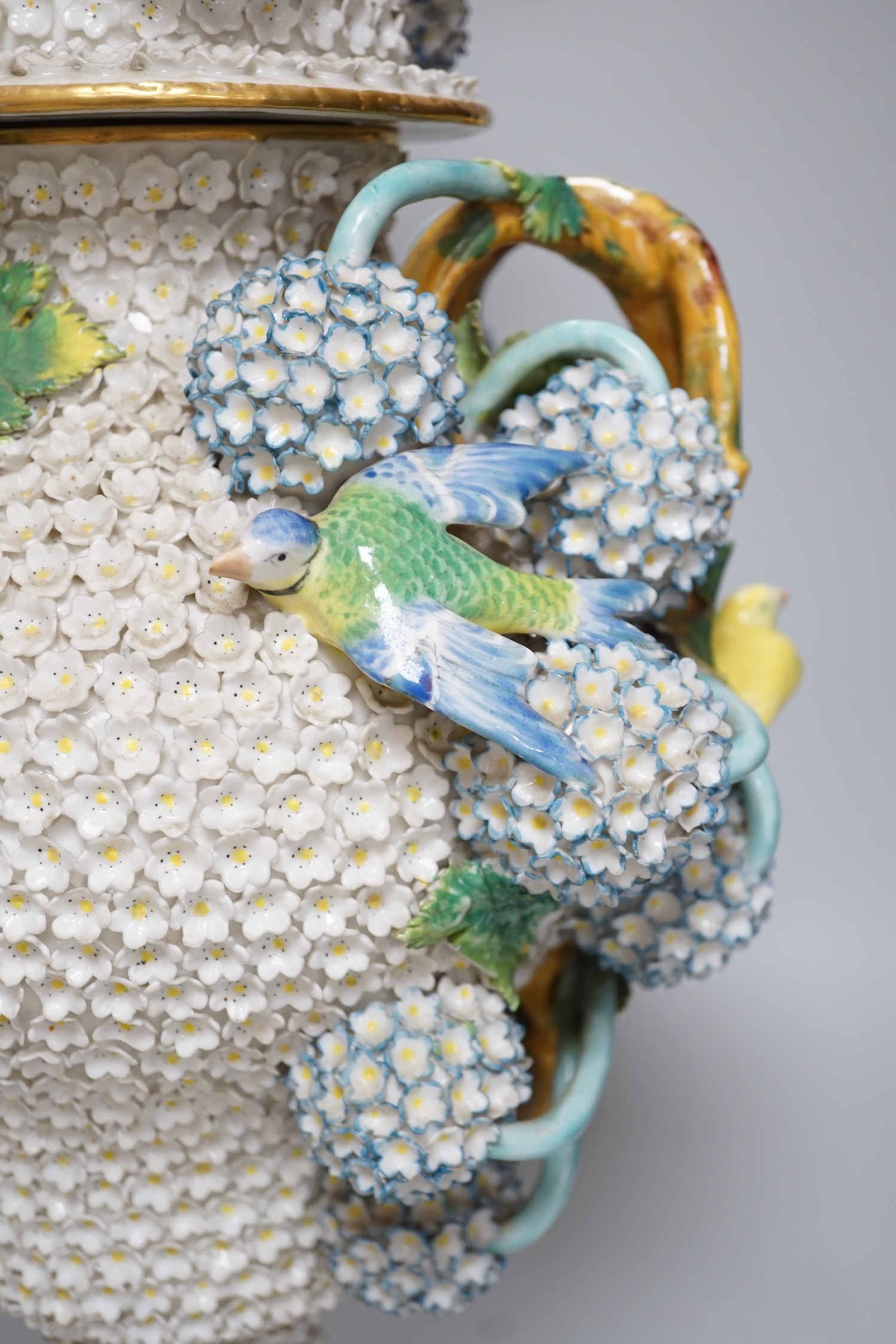 A large 19th century Jacob Petit floral encrusted two handled vase and cover, decorated with birds and flowers, 64cms high